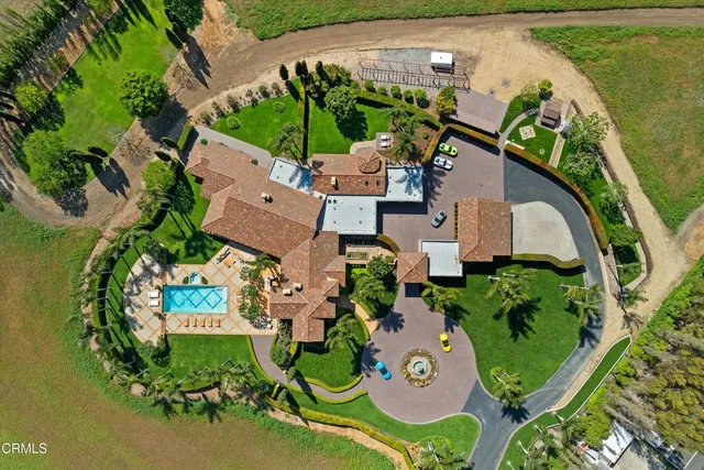 an aerial view of a house with a garden and lake view
