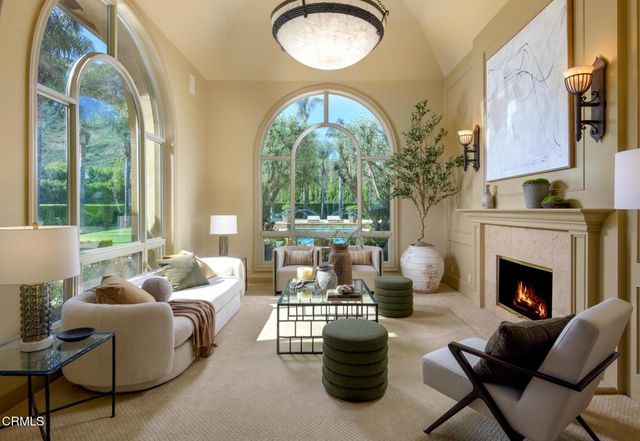 a living room with furniture a fireplace and a large mirror