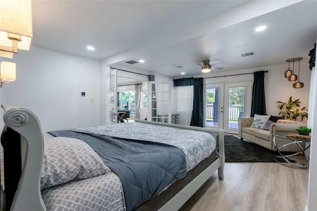 a spacious bedroom with a bed a couch and dresser