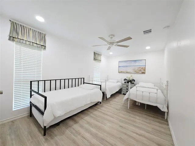 a spacious bedroom with a bed and a chandelier