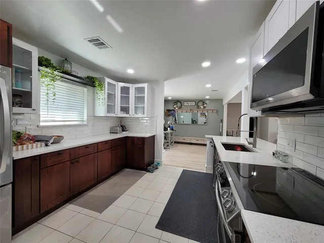 a kitchen with stainless steel appliances a refrigerator a sink dishwasher with a stove and cabinets