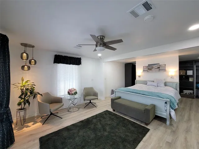 a spacious bedroom with a bed and a chandelier
