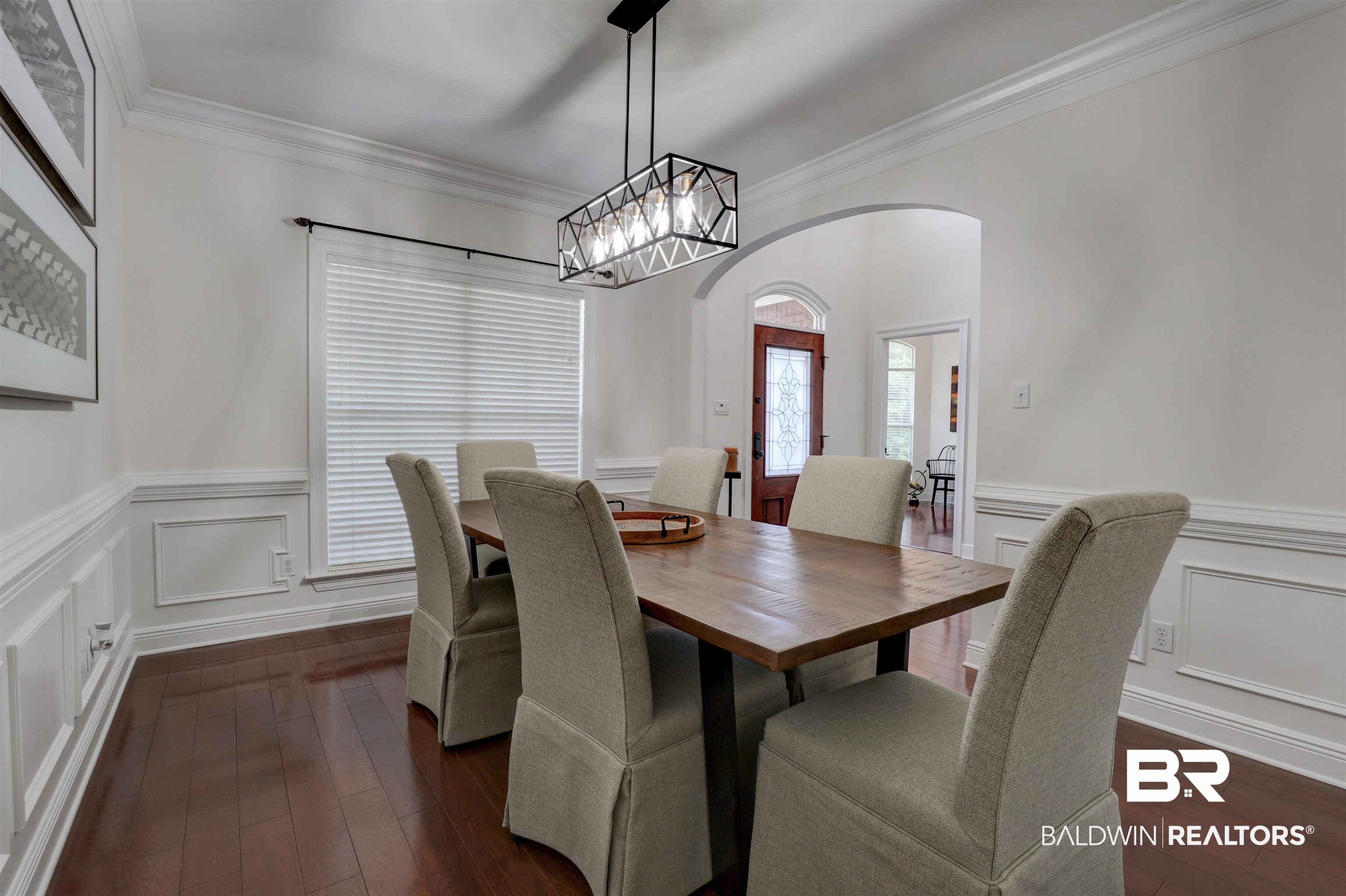 5565 Dawes Lane Theodore, AL 36582 - Photo 4 of 38 Dining area with crown molding, dark wood-type flooring, and a notable chandelier
