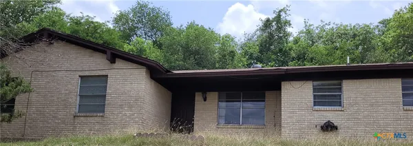 a front view of a house with trees