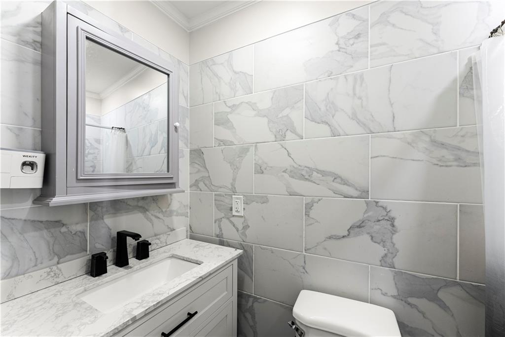 5626 Austell Powder Springs Road Southwest Austell, GA 30106 - Photo 26 of 36 a bathroom with a toilet sink vanity and mirror
