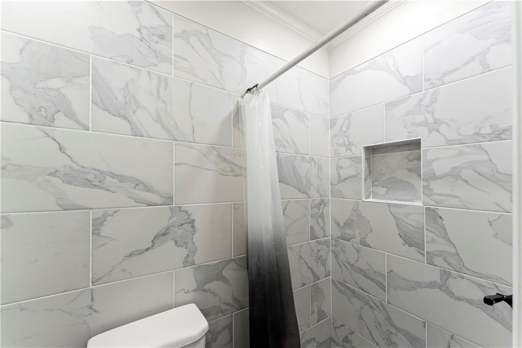 5626 Austell Powder Springs Road Southwest Austell, GA 30106 - Photo 27 of 36 a white toilet sitting next to a bathroom sink