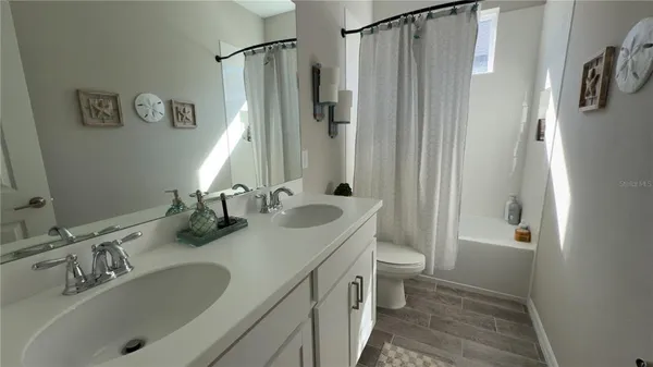 a bathroom with double vanity sink toilet and shower