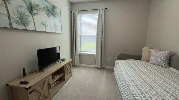 a bedroom with a bed and a flat screen tv