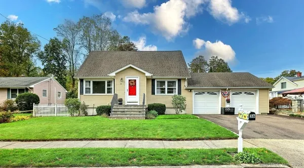a front view of a house with a garden and plants