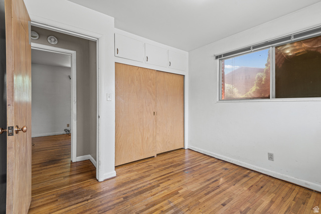 542 East 3400th Street North Provo, UT 84604 - Photo 22 of 39 Hardwood flooring throughout, featuring a built-in closet with natural wood doors and overhead cabinetry