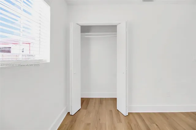 a view of a room with wooden floor and a window
