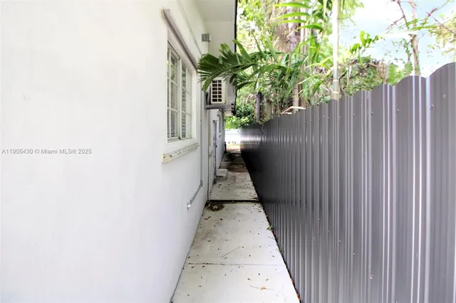 a view of a pathway of a house with wooden fence