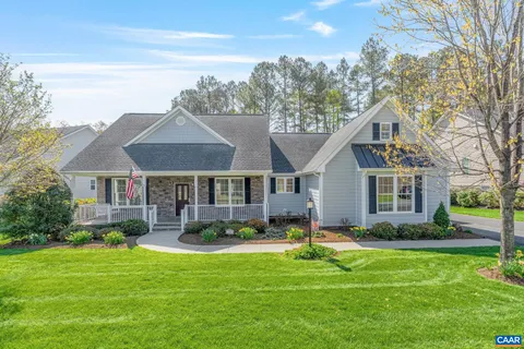 a front view of a house with a yard and potted plants
