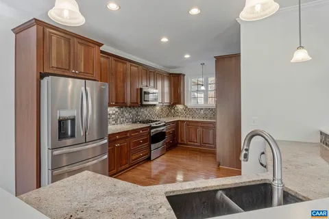 a kitchen with stainless steel appliances granite countertop a sink stove and microwave