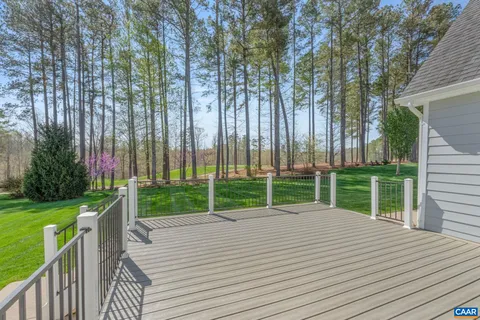 a view of a deck with a big yard and large trees