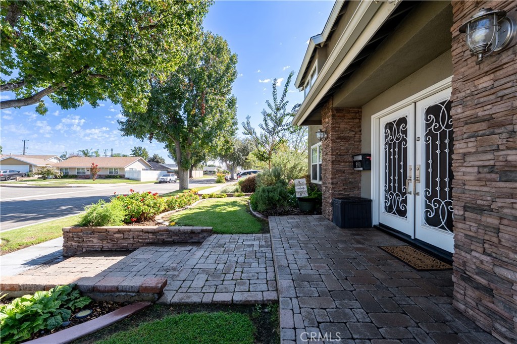 390 North Milford Road Orange, CA 92867 - Photo 61 of 70 Beautifully professionally landscaped front yard with Stone pavers, mature trees, and custom stacked stone columns.