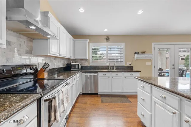a kitchen with stainless steel appliances granite countertop a sink stove and cabinets