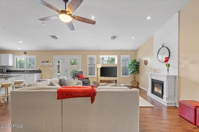 a kitchen with stainless steel appliances granite countertop a stove a refrigerator a sink a dining table and chairs with wooden floor