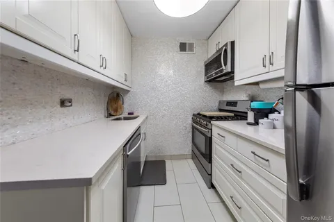 a kitchen with stainless steel appliances a sink stove and cabinets