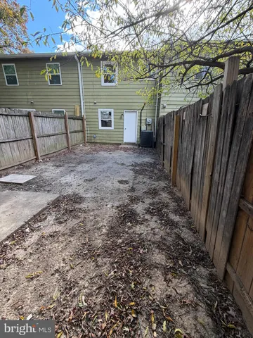 a view of a backyard with table and chairs and wooden fence