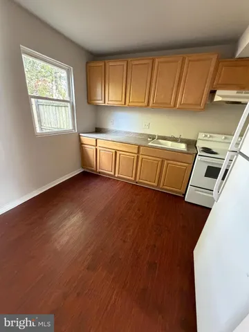 a view of a kitchen with wooden floor and staircase
