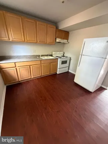 a kitchen with a sink a stove and cabinets
