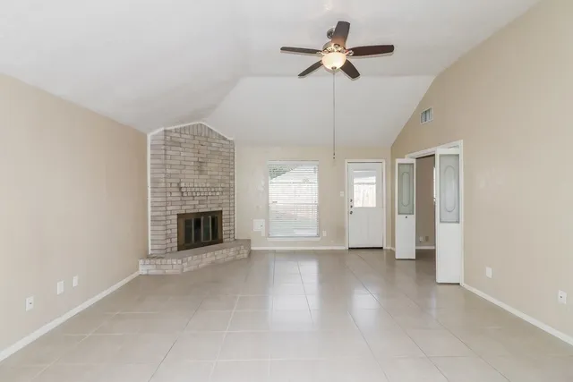 a view of an empty room with a fireplace and a window