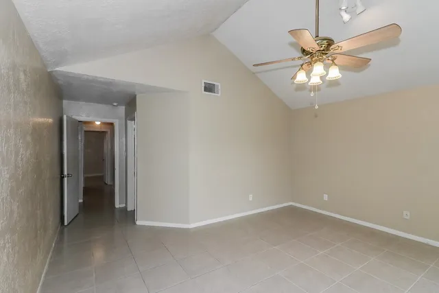 wooden floor in an empty room and a chandelier fan