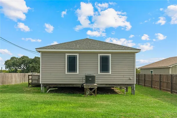 a backyard of a house with potted plants and a large tree