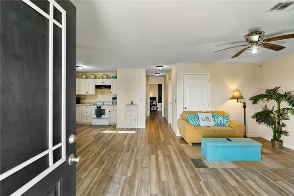 a living room with furniture and a wooden floor