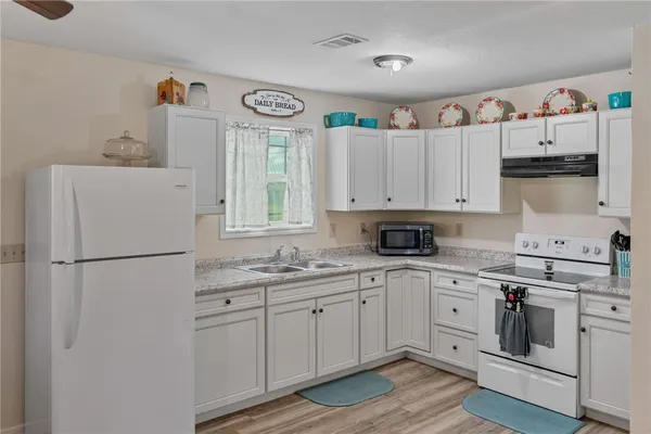 a kitchen with white cabinets sink and white appliances