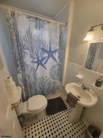 a bathroom with a toilet sink and mirror