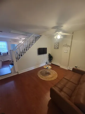 a living room with furniture and a wooden floor