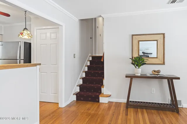 a view of a hallway with wooden floor and staircase