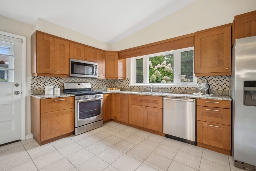 401 Locust Road Wilmette, IL 60091 - Photo 4 of 32 a kitchen with stainless steel appliances granite countertop a stove a sink and a refrigerator