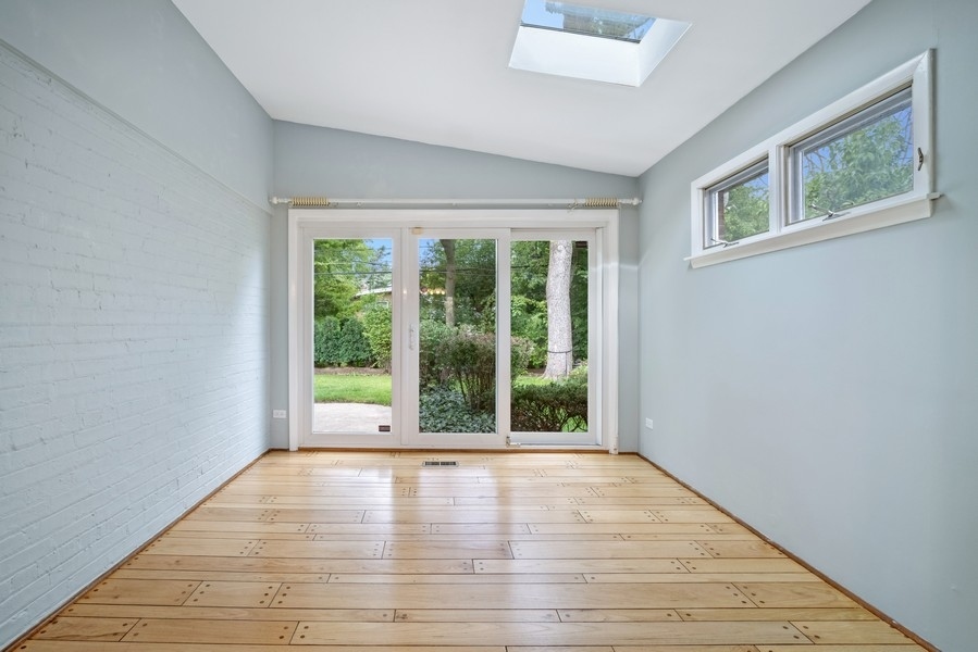 401 Locust Road Wilmette, IL 60091 - Photo 8 of 32 a view of an empty room with wooden floor and a window