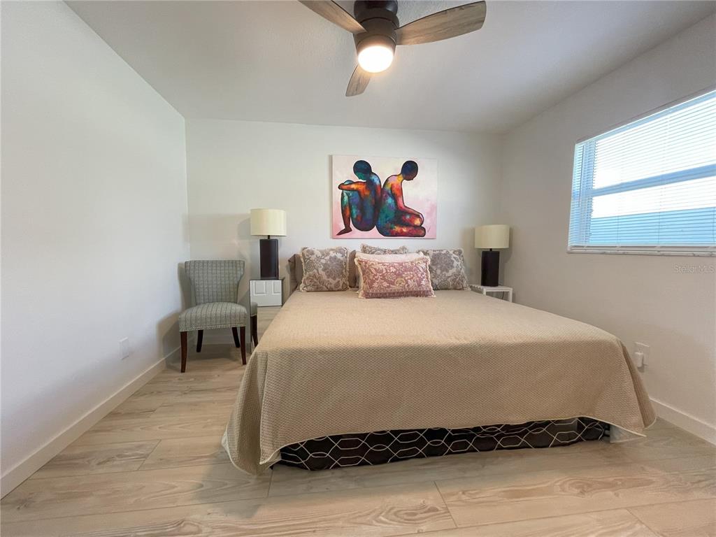 250 Rosery Road Northwest, Unit 329 Largo, FL 33770 - Photo 11 of 27 a bedroom with a bed and a painting on the wall