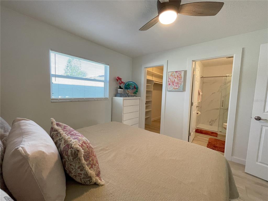 250 Rosery Road Northwest, Unit 329 Largo, FL 33770 - Photo 13 of 27 a bedroom with a bed and a chandelier