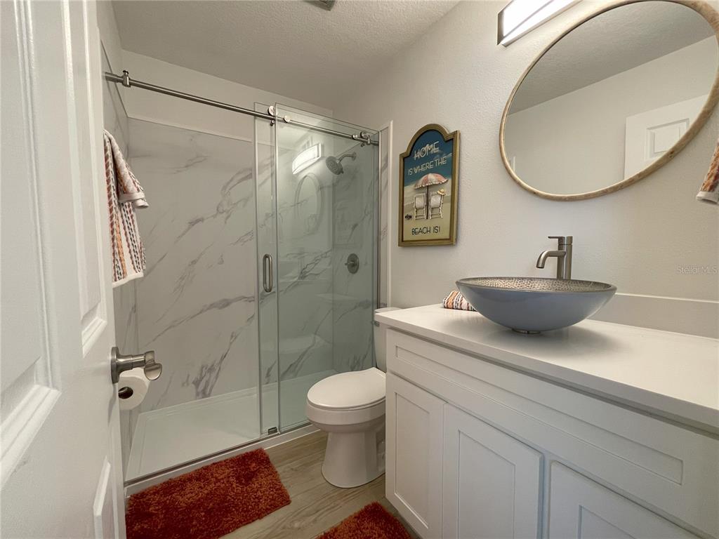 250 Rosery Road Northwest, Unit 329 Largo, FL 33770 - Photo 16 of 27 a bathroom with a sink a toilet and a mirror