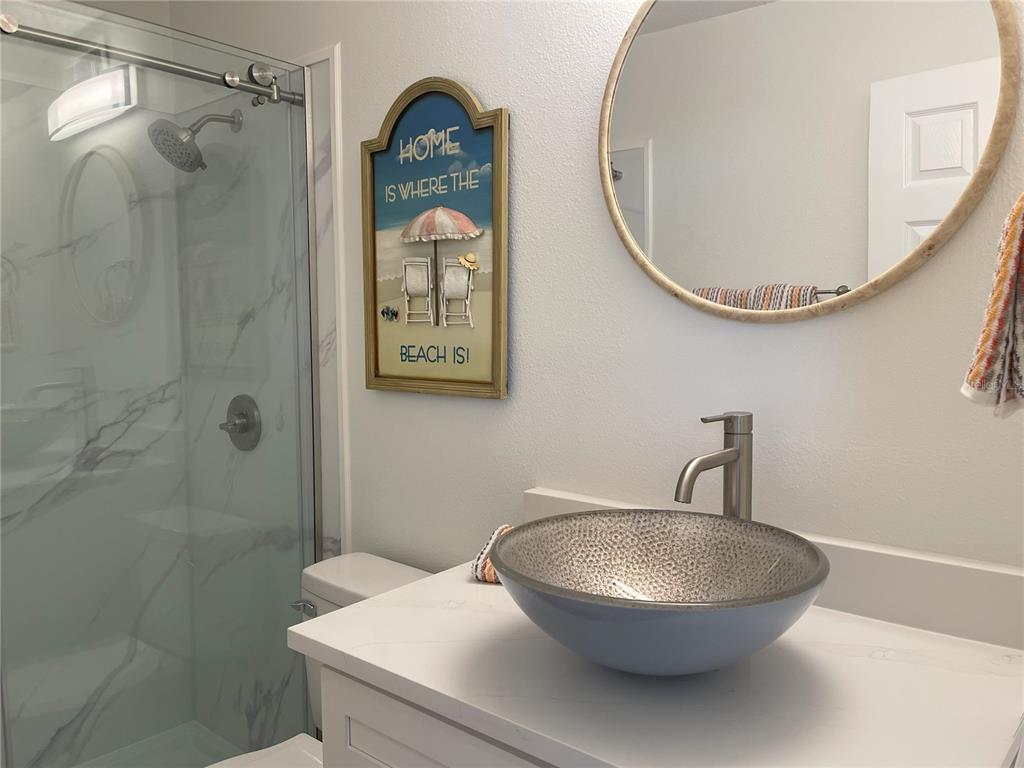250 Rosery Road Northwest, Unit 329 Largo, FL 33770 - Photo 17 of 27 a bathroom with a sink mirror toilet and shower