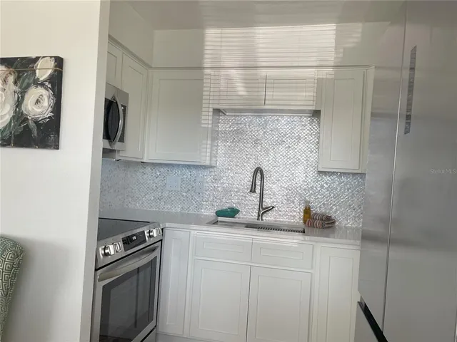 a kitchen with stainless steel appliances a sink stove and cabinets