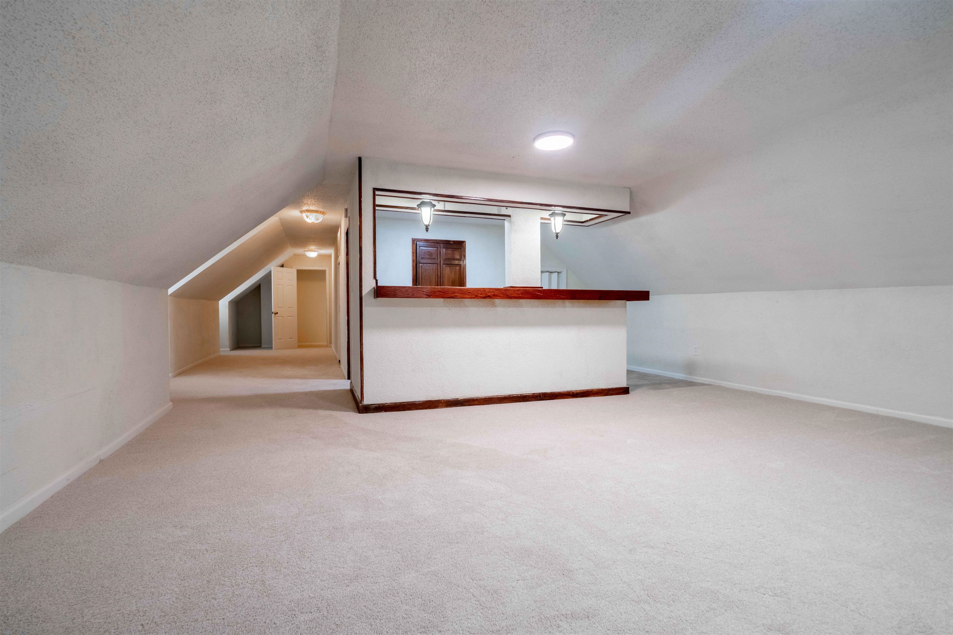 7800 Buck Ridge Cove Memphis, TN 38016 - Photo 32 of 36 Spacious carpeted room featuring a built-in bar with a wood-finish countertop, recessed lighting, and sloped ceilings