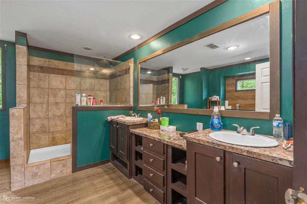9489 Capps City Road Rodessa, LA 71069 - Photo 15 of 24 Bathroom featuring a tiled walk-in shower with a glass panel