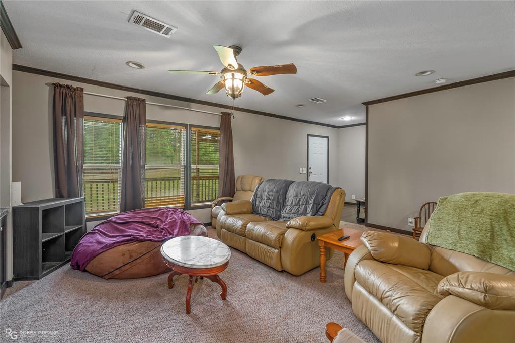 9489 Capps City Road Rodessa, LA 71069 - Photo 5 of 24 Spacious living area featuring carpet flooring and neutral wall tones