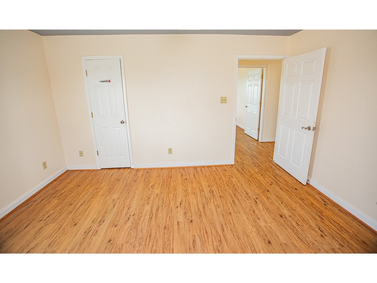 419 Thunder Road Surfside Beach, TX 77541 - Photo 20 of 32 Cozy room with light wood flooring, neutral walls, and two white doors leading to adjacent areas. Ideal for a bedroom or office space.