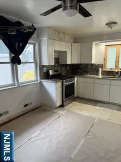 a kitchen with stainless steel appliances granite countertop a sink a stove and a refrigerator