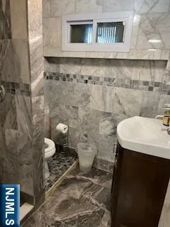 a bathroom with a sink a toilet and a mirror