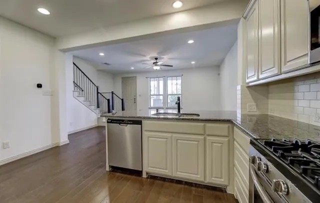 a kitchen with stainless steel appliances granite countertop a sink stove and microwave