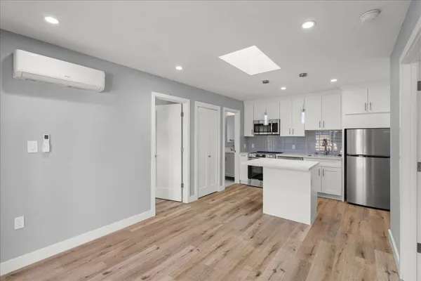 a kitchen with a refrigerator and white cabinets