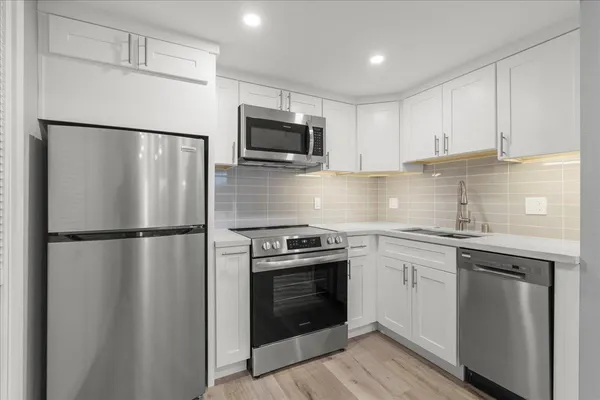 a kitchen with a refrigerator sink and stove